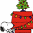 A red doghouse with green and yellow string lights, a small Christmas tree on top, and Snoopy lying beside it.