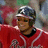 A pixelated image shows a person wearing a red jacket with white trim, dark hair under a silver helmet-like cap, and a black collar visible beneath the jacket.