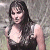 A pixelated image of a woman with long dark hair wearing a low-cut sleeveless top, positioned next to green text reading 'Original Icons .com' on a solid background.