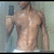 A shirtless person in a mirror selfie holding a dark smartphone, with visible torso muscles and white underwear waistband.