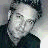 A 48x48 pixel buddy icon featuring a grayscale photo of a man with short dark hair and glasses, paired with text elements on a gray background.