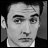 Black-and-white pixelated static image of a human face with visible facial features and grayscale shading.