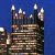 A pixelated image split into two sections: a blue background with stacked brown and white structures on the left, and green text reading "Original Icons .com" on the right.