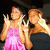 Two pixelated figures in a static image: one in pink dress with raised hand, the other in dark top holding an object.