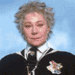 nine shows a person with curly light brown hair in a black outfit with white collar and tie, wearing a white flower pin, against a light blue background with "Madam Hooch" text overlays