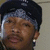 A person wearing a dark cap and light bandana with subtle facial expression changes across four