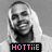 Pixelated grayscale portrait of a person with long light hair and dark clothing, overlaid by pink text reading HOTTiE on black background.