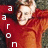 A person in a red hoodie with text elements changing across frames, showing 'aaron' vertically and 'oh' horizontally.