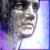 Pixelated close-up of a person's face with dark hair, light skin tone, and visible mouth showing teeth against purple and blue gradient background.