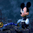 Pixelated character with black ears and white face holding a blue object against dark background.