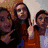 Four people pose together in a group photo with one person making a peace sign, transitioning to grayscale and then colorized sections.