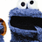 Blue furry character with large black eyes and a wide open mouth, holding an orange cookie in one hand.