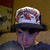 A person wearing a white cap with red and black patterns and a dark shirt, shown in a of four with slight variations in head position and background