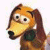 Pixelated cartoon dog with orange-brown fur, large eyes, and a dark green collar, facing left against a white background.