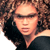 Animated contact sheet of a celebrity with curly hair in two poses, alongside a website logo on blue background.