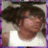 Pixelated image of a person with dark hair wearing a white shirt, set against a light background with purple border accents.