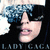 Pixelated image of a person with dark hair and sunglasses, wearing a black top, with text overlays reading 'LADY GAGA', 'JUST DANCE', 'GONNA BE OK!'