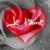 A red heart-shaped icon with a white cross-like symbol inside, set against a gray pixelated background.