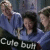Three pixelated figures in blue shirts pose together with one figure raising an arm, below white text reading "Cute butt" on a dark background.