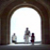 Pixelated image of three vertical objects under an archway with bright background, showing partial details of shapes and colors.