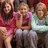 Three figures in a group pose with one figure holding a pink object, all rendered in low-resolution pixelated style.