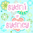 Pixelated image with light blue background, green and cyan floral patterns, pink text overlays including 'sydri', 'sydney', 'BFFLS!!!', 'blonde at', 'Lylas', and a peach heart symbol.