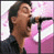 Static pixelated image of a person singing into a microphone with pink and white background elements.