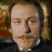 A 48x48 pixel animated contact sheet showing two sequential frames of a character with light skin, mustache, and dark hair against a blurred background.