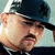Two side-by-side pixelated images of a man wearing dark sunglasses and a cap, one with light background, the other with darker tones.