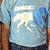 A pixelated group of four people in casual clothing, with one person wearing a light blue shirt featuring a white graphic design.