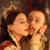 Two people in close physical proximity with eyes closed, sharing a kiss, one wearing a red and white garment, the other in light-colored clothing, against a dark background.