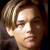 Static pixelated image of a person's face with light brown hair and visible facial features including eyes, nose, mouth, and ear against dark background.
