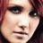 Pixelated close-up of a person's face with dark hair, visible eyes, nose, mouth, and light skin tone.