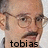 Pixelated close-up of a person's face with glasses and mustache, featuring the text 'tobias' at the bottom.