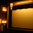 A pixelated static image showing a golden theater interior with dark wooden trim and multiple illuminated light fixtures.