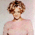 A pixelated image of a person with short curly brown hair wearing a light pink top and dark choker necklace against a pale background.