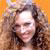 A pixelated image of a person with curly brown hair on an orange background, with text elements in yellow and red on adjacent orange and gray sections.