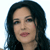 Pixelated close-up of a person with long dark hair, light skin, and pink lips against a white background.