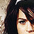 Pixelated close-up of a person's face with dark hair, light skin tone, and visible eye details against a neutral background.