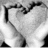 Black-and-white pixelated image of two hands forming a heart shape with text reading 'I love you' in red.
