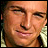 A 48x48 pixel buddy icon split into two frames: left frame shows a close-up of a person's face with squinted eyes and a slight smile, right frame displays a pink heart outline containing blue text "What a hottie" on a light pink background.