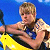 Pixelated image of a person with light brown hair holding a yellow object against a blue background.