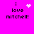 Pixelated text 'i love mitchell!' on bright pink background with animated white heart and star symbols.