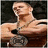 A shirtless man with short hair holds a large dark object in his right hand, then shifts to hold it with both hands against a black background.