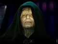 Static image of a hooded figure with pale skin and red eyes against dark background, likely from Star Wars franchise.