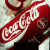 12 identical Coca-Cola bottle images with changing text overlays in black rectangular boxes
