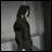 Pixelated grayscale image of a figure in dark clothing standing near a wall with text reading 'AnimeIM' and 'com' on the right side.