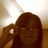 Pixelated image of a person with long brown hair holding a phone to their ear against a light background.