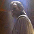 Pixelated static image of a figure with light-colored hair and clothing against a gradient background, showing partial facial features and body shape.
