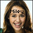 Pixelated close-up of a person with long brown hair, wearing a white earring, with the text 'Miley' overlaid in black block letters across the forehead.